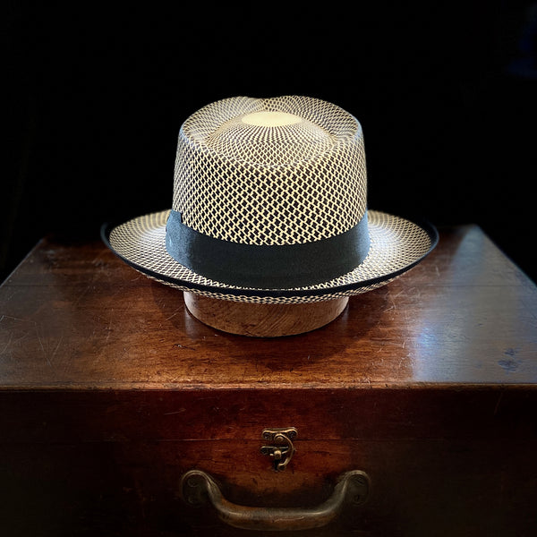 Black and white patterned short brim Panama hat with black grosgrain bow headband