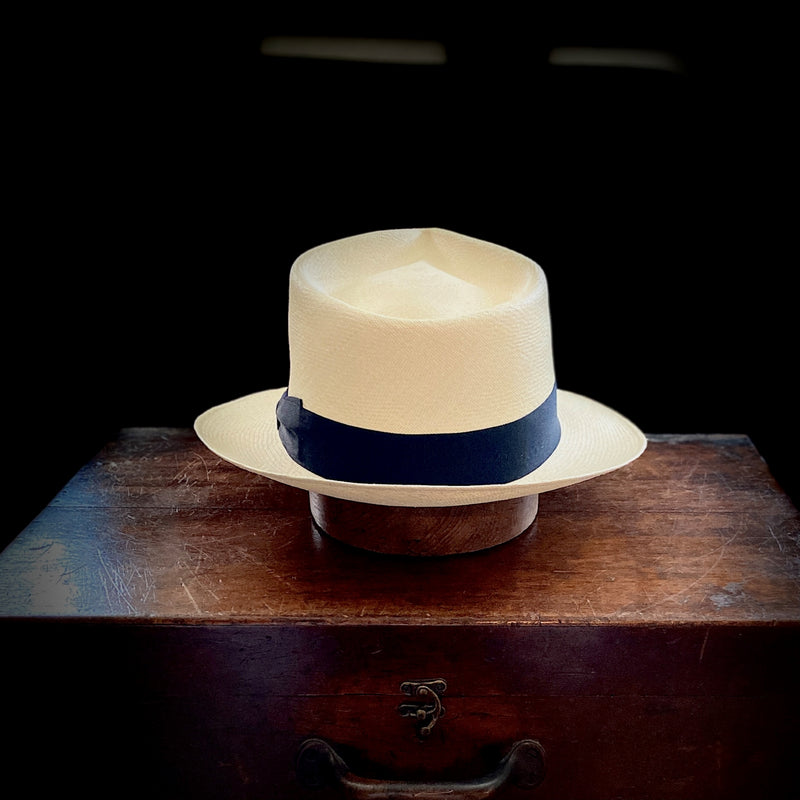 semi bleached straw, 6cm brim Panama hat with an exaggerated pinched crown black grosgrain headband